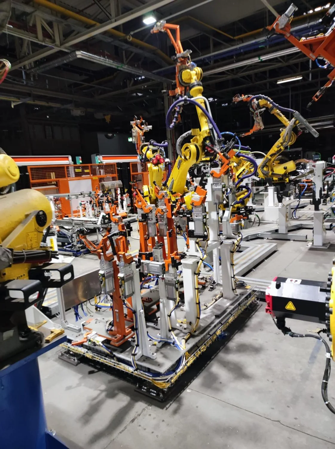 Robot przemysłowy w celi produkcyjnej